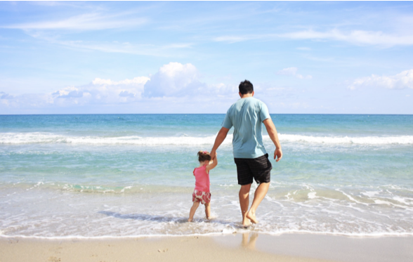 padre con niña en playa