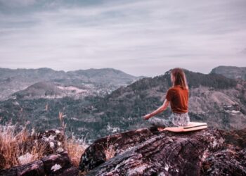 Mujer meditando en la montaña