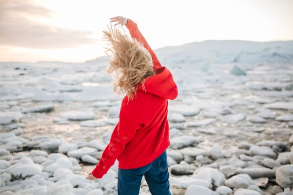 Mujer de rojo en playa de piedras