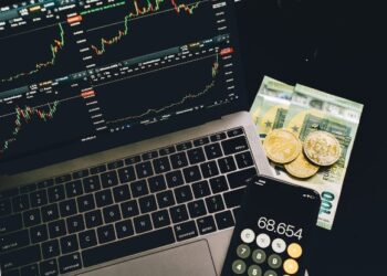 PC con inversiones, calculadora y dinero