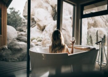 Mujer en bañera de lujo tomando vino