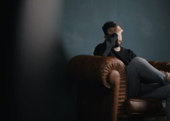 Hombre preocupado sentado en sofa