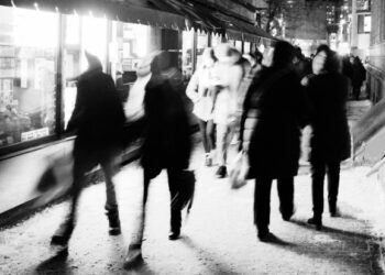 Una imagen borrosa por movimiento de personas caminando por una calle concurrida