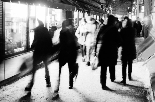 Una imagen borrosa por movimiento de personas caminando por una calle concurrida