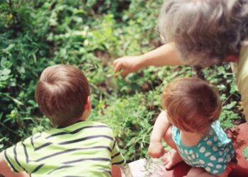 Abuela con nietos viendo plantas