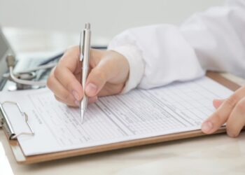 Doctora rellenando documento
